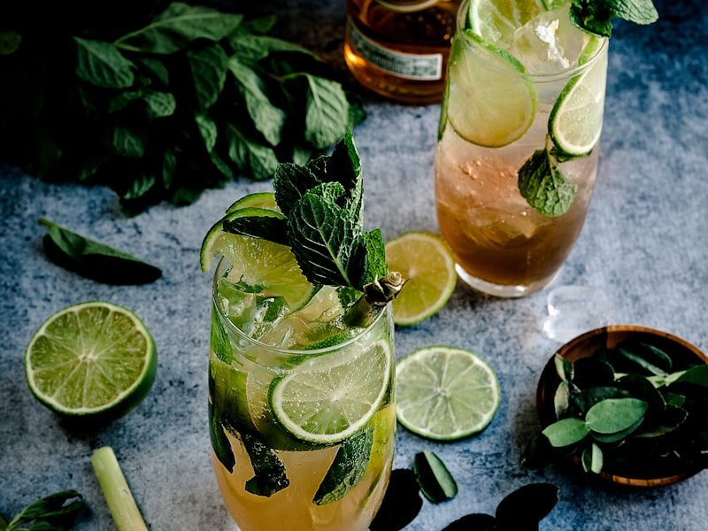Pair of mojito cocktails with mint, lime, and rum on a bar surface