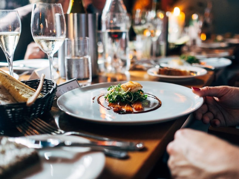 Plated fine-dining main course on white plate with garnish at restaurant table